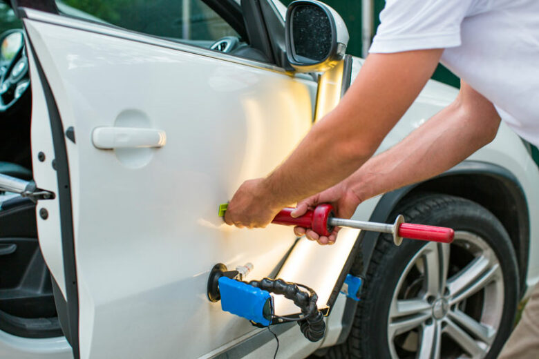 Mechanic using paintless dent repair technique in Gunter, TX