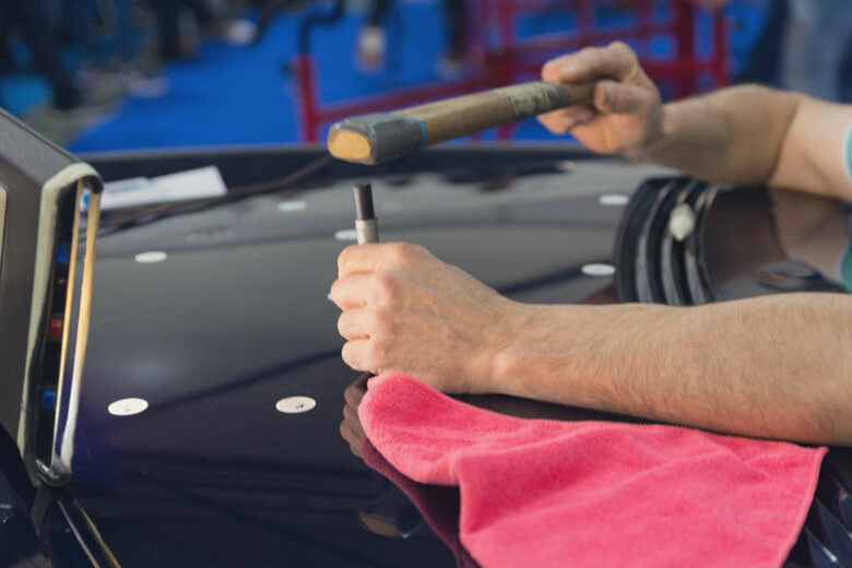 Mechanic performing PDR Vehicle Dent Repair in Corinth, TX